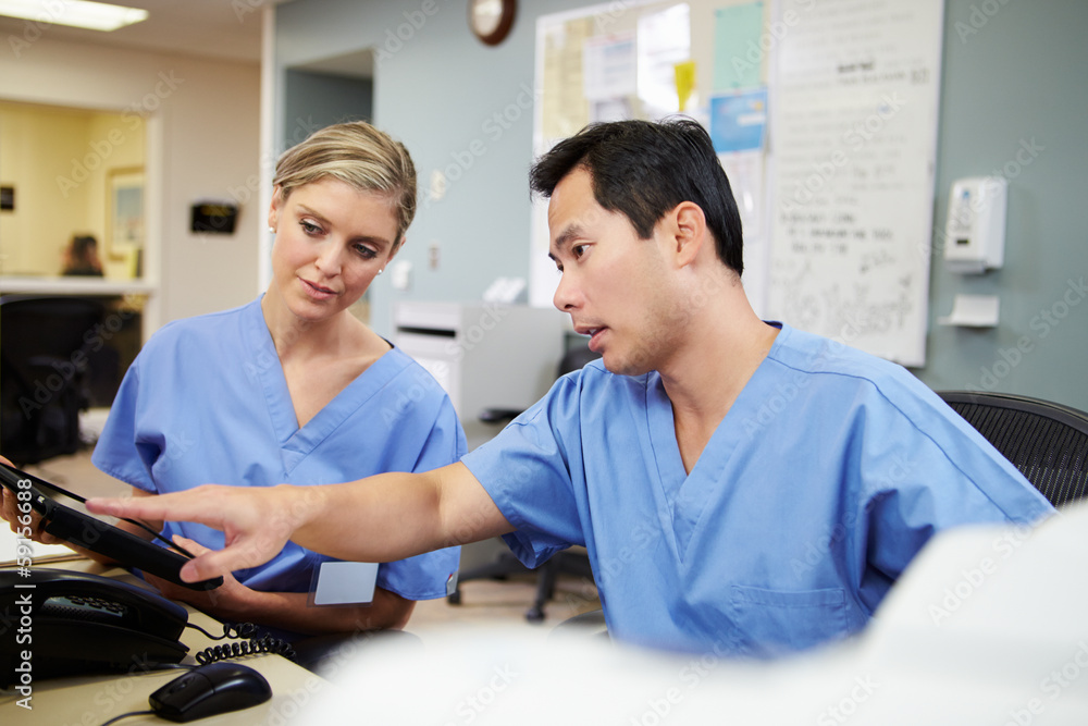 Obraz premium Male And Female Nurse Working At Nurses Station