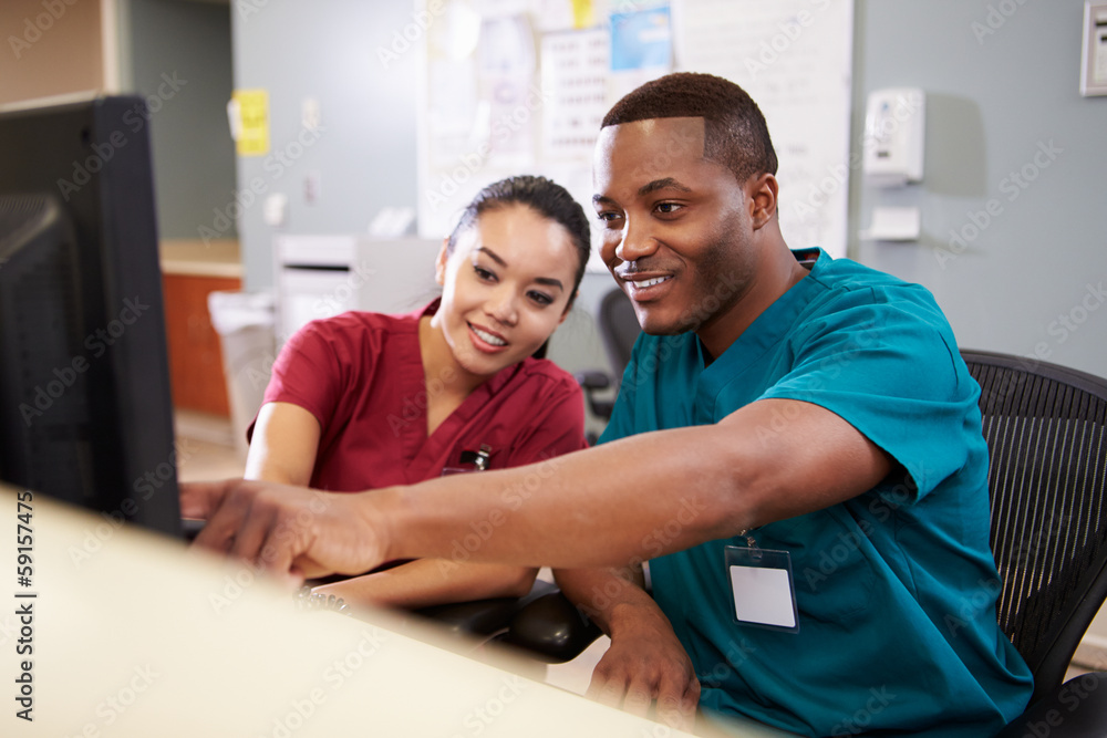 Obraz premium Male And Female Nurse Working At Nurses Station