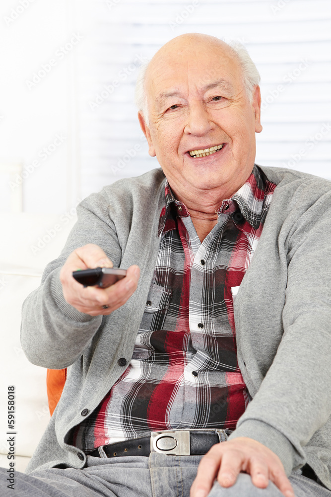 Senior man with remote control watching TV Senior man with remote control watching TV