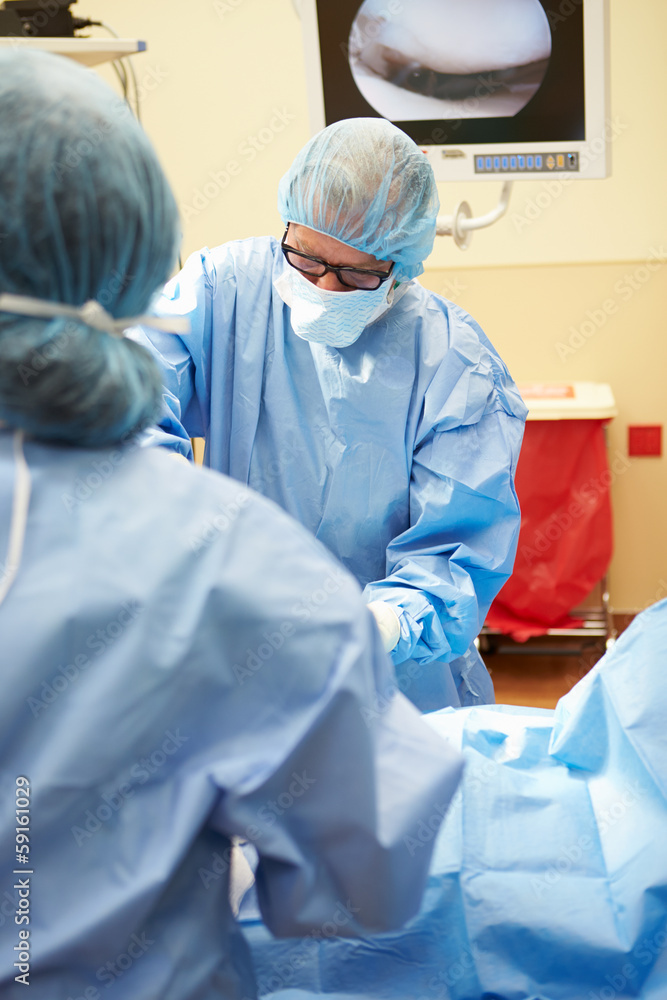 Surgical Team Working In Operating Theatre Surgical Team Working In Operating Theatre
