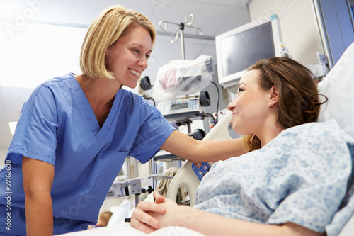 Fototapeta Young Female Patient Talking To Nurse In Emergency Room
