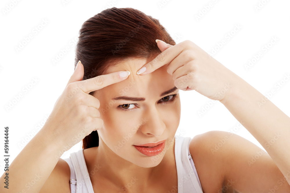 Young woman is pimpling spot on forehead. Young woman is pimpling spot on forehead.