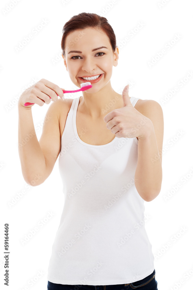 Beautiful woman in white top is brushing her teeth. Beautiful woman in white top is brushing her teeth.