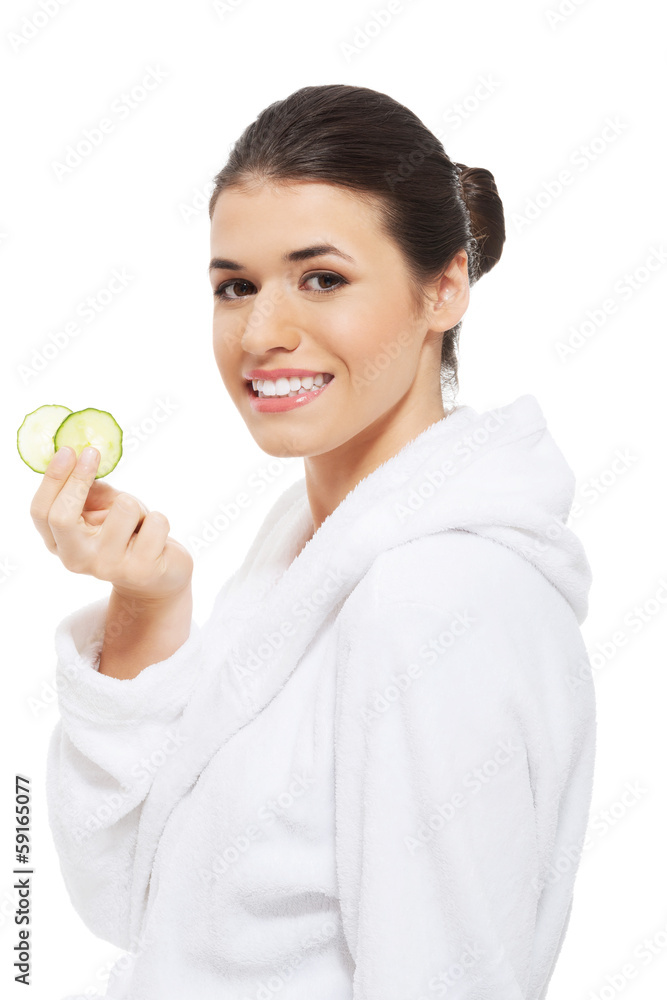 Beautiful woman in bathrobe holding cucumbers. Beautiful woman in bathrobe holding cucumbers.