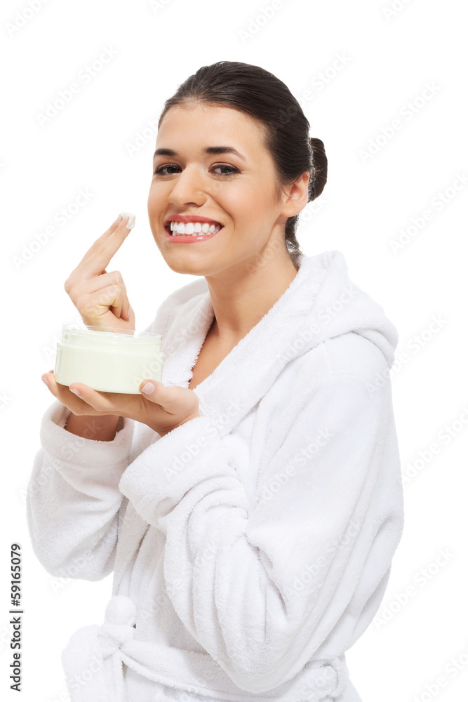 Beautiful woman in bathrobe with face cream. Beautiful woman in bathrobe with face cream.