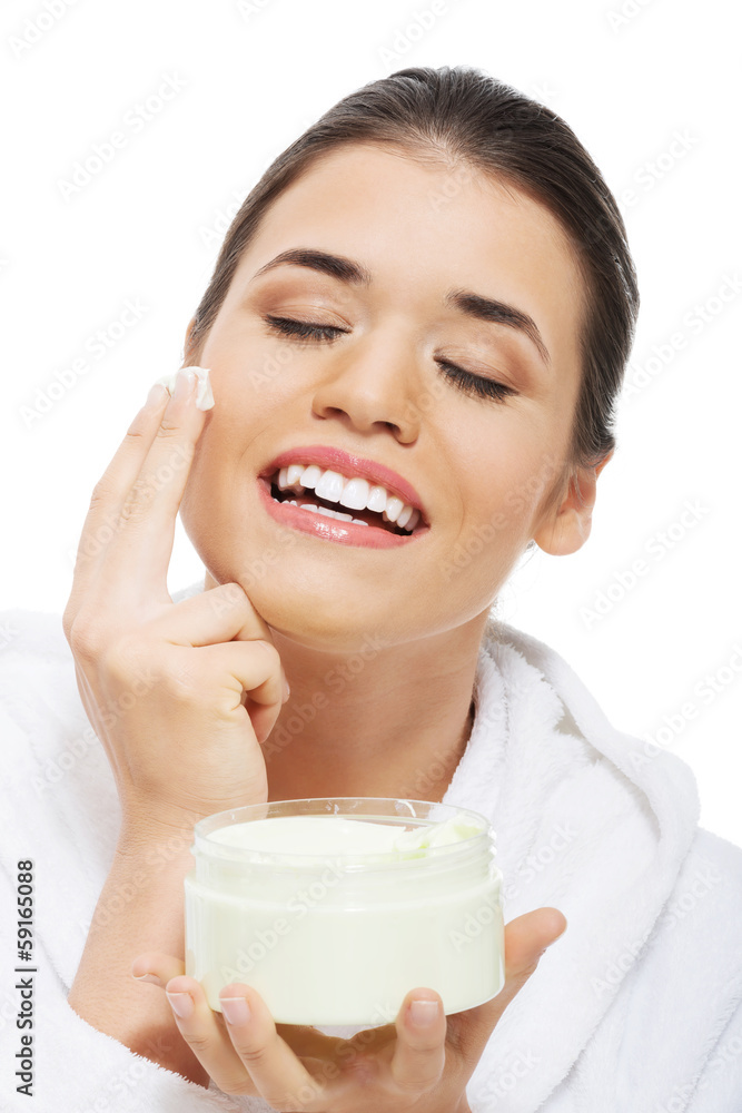 Beautiful woman in bathrobe with face cream. Beautiful woman in bathrobe with face cream.