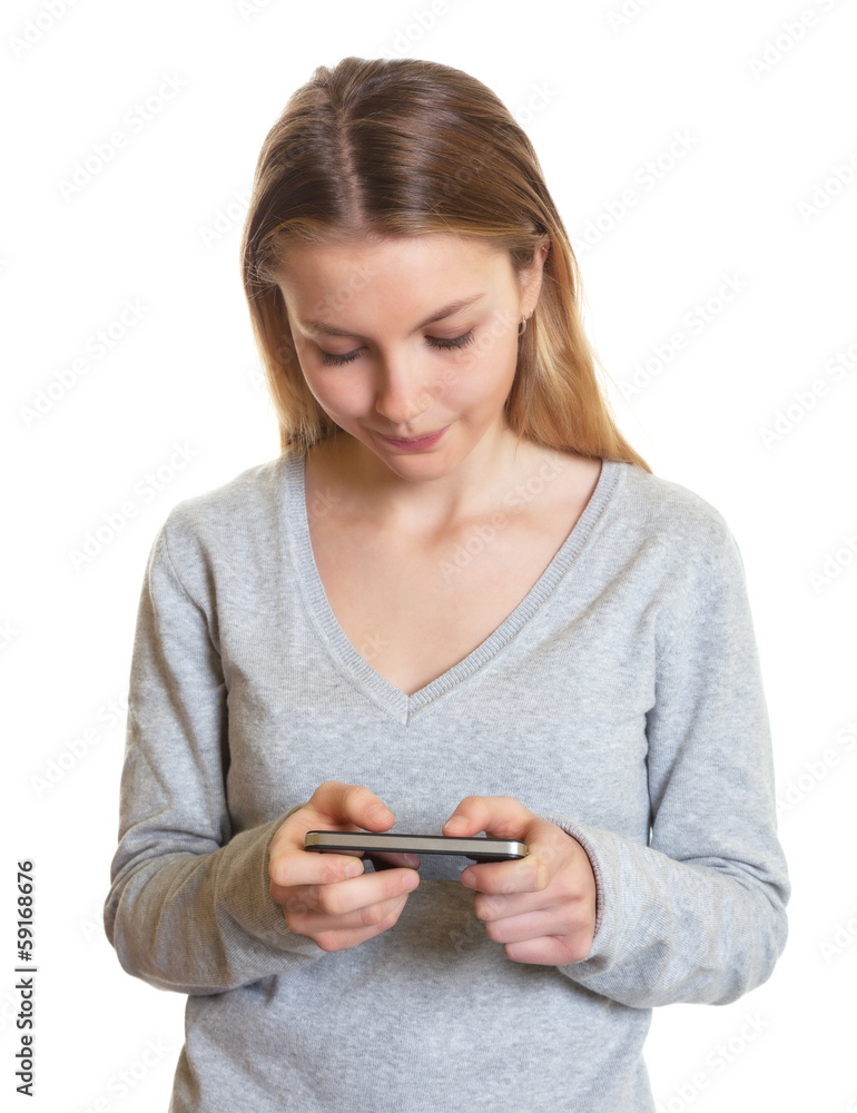 Junge Frau im grauen Pulli schreibt eine SMS Junge Frau im grauen Pulli schreibt eine SMS