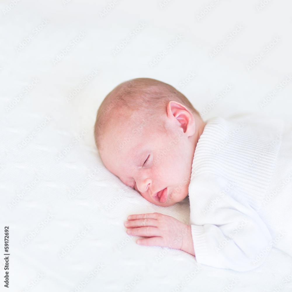 Adorable newborn baby sleeping on a white blanket Adorable newborn baby sleeping on a white blanket