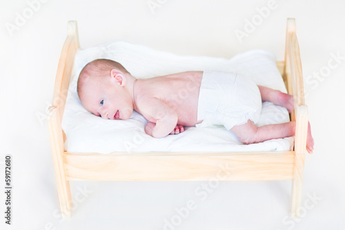 Tiny newborn baby in a toy bed