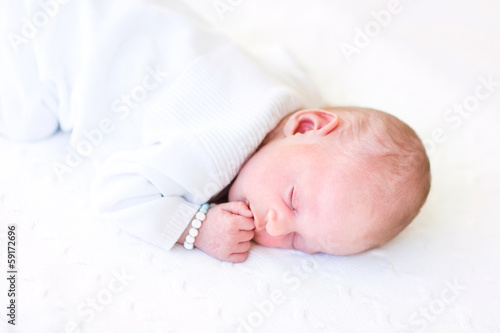Cute tiny baby sleeping on a knitted blanket