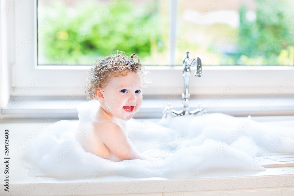 Happy laughing baby girl having fun playing with water and foam Happy laughing baby girl having fun playing with water and foam