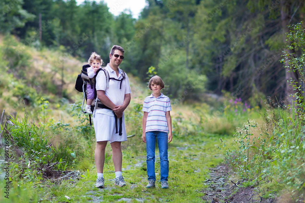 Family, father, his son and a baby daughter in a hiking trail