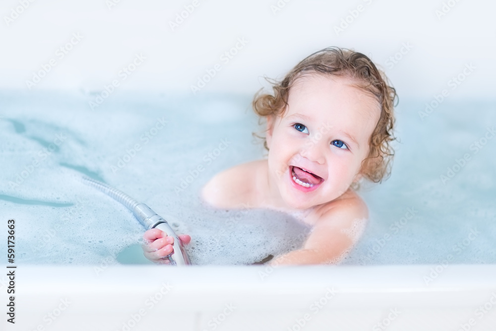 Beautiful little baby girl with big blue eyes playing in a bath Beautiful little baby girl with big blue eyes playing in a bath