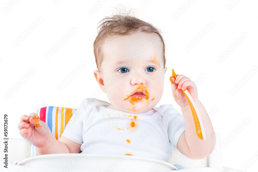 Funny messy baby eating her first solid vegetable food Funny messy baby eating her first solid vegetable food