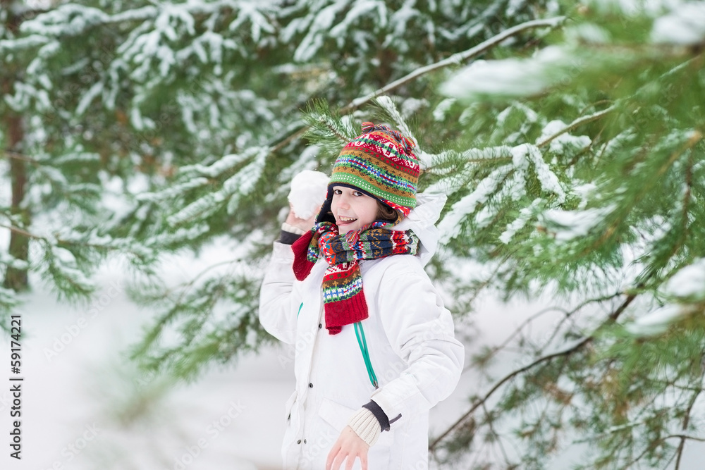 Funny cute boy playing snow ball in a snowy winter park Funny cute boy playing snow ball in a snowy winter park