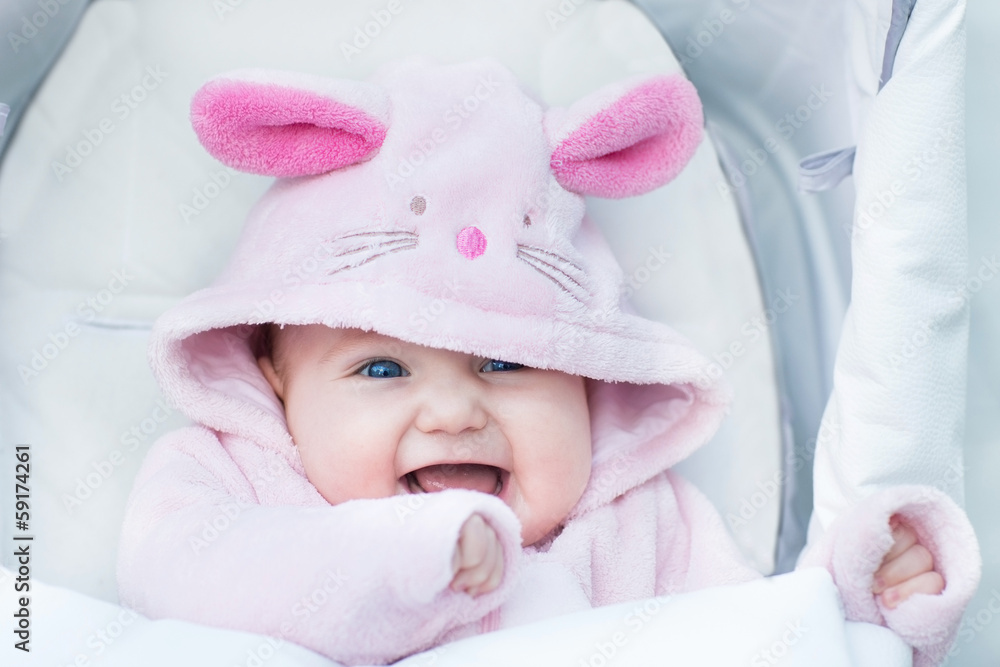 Funny baby girl sitting in a stroller in a bunny snow suit Funny baby girl sitting in a stroller in a bunny snow suit