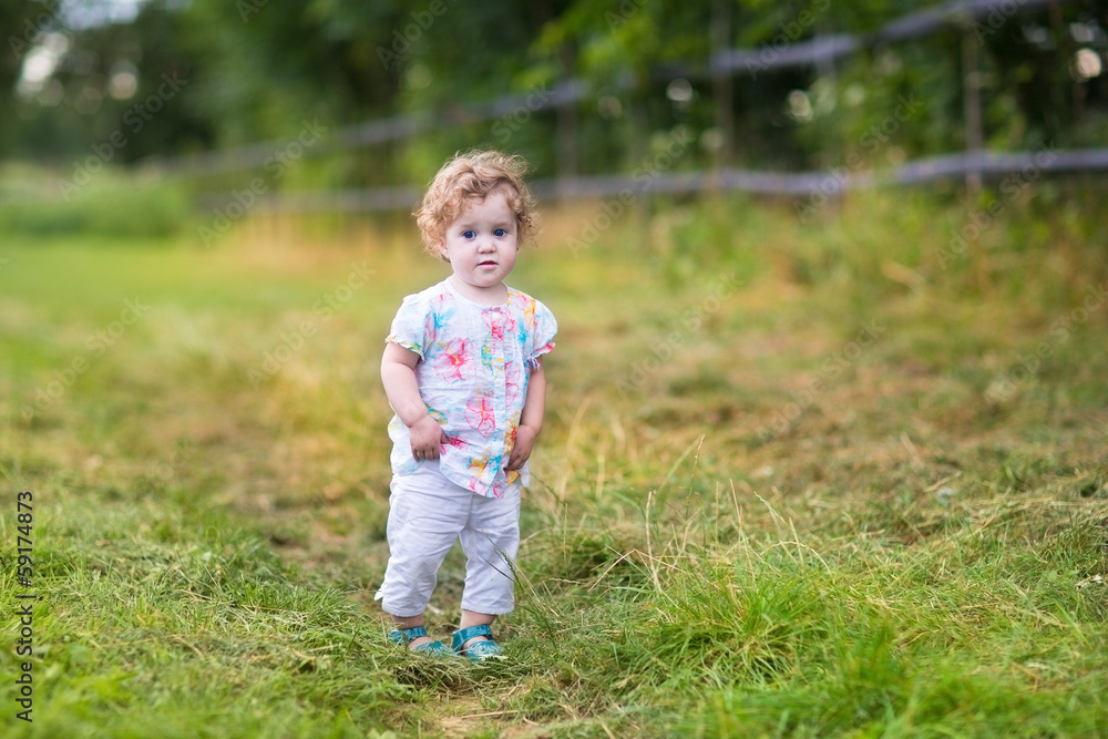 Beautiful baby girl walking on a country road at sunset Beautiful baby girl walking on a country road at sunset