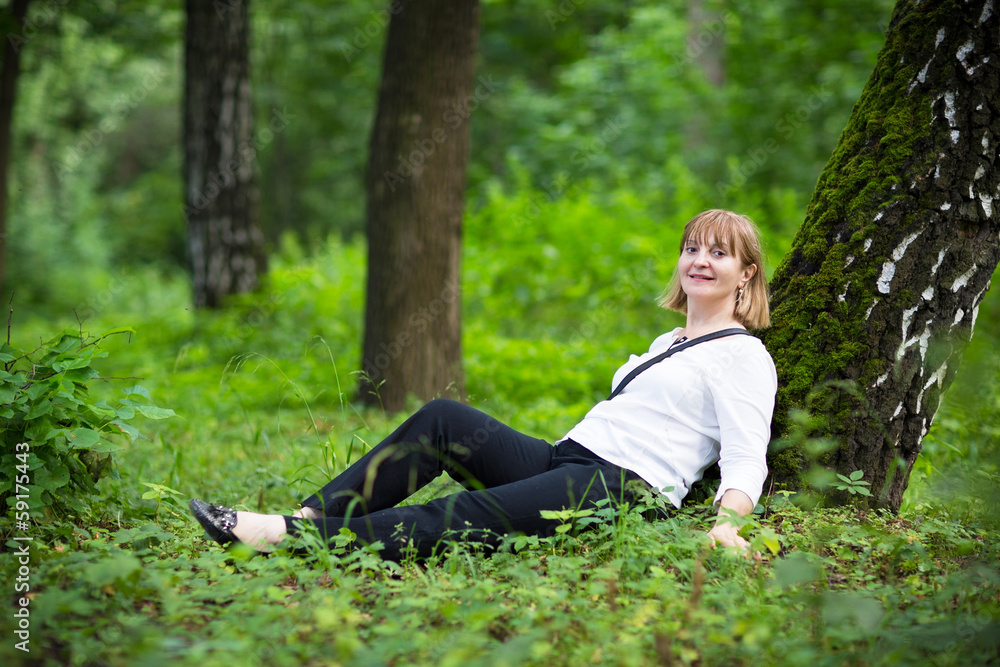 Beautiful woman relaxing under a big old tree Beautiful woman relaxing under a big old tree