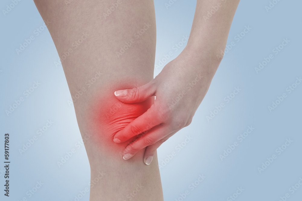 Acute pain in a woman  knee. Female holding hand to spot of knee