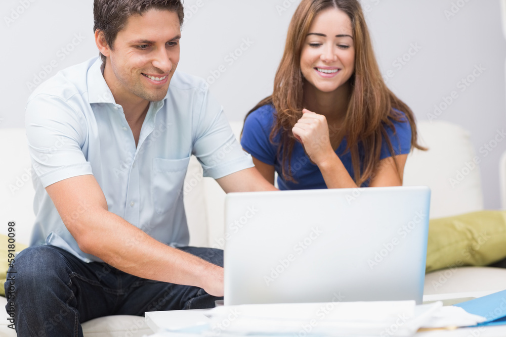 Cute couple using laptop at home