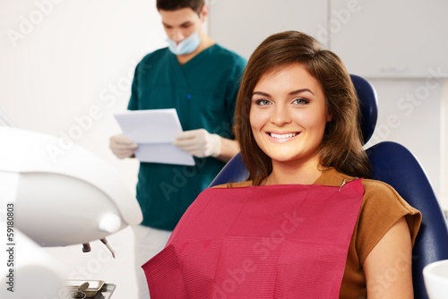 Man dentist reading woman patient s card