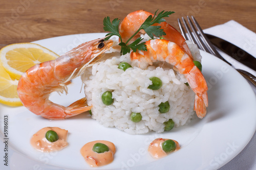 Rice with shrimps and green peas on the table