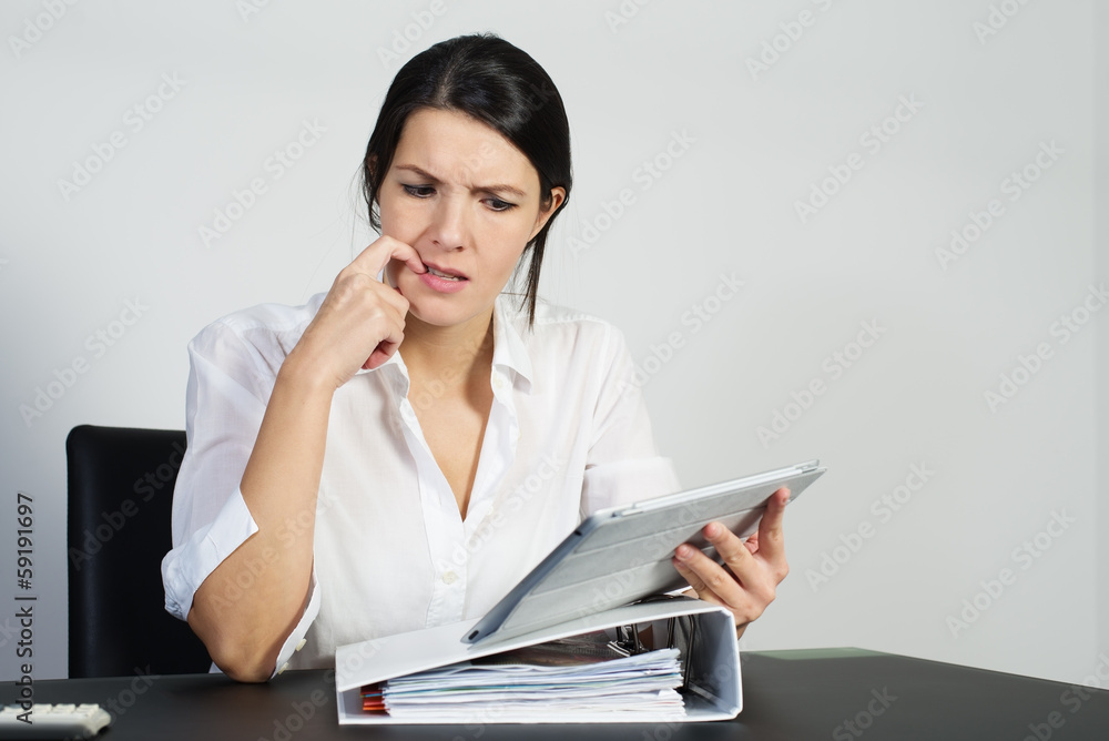 Verwirrte Frau brütet über einem Problem mit einem Tablet Verwirrte Frau brütet über einem Problem mit einem Tablet