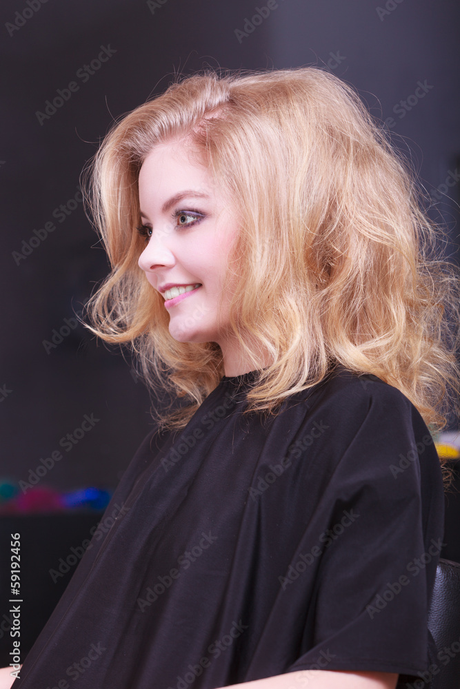Fototapeta premium Beautiful girl blond wavy hair in hairdressing beauty salon