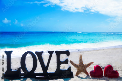 Sign "Love" with heart shapes and starfish