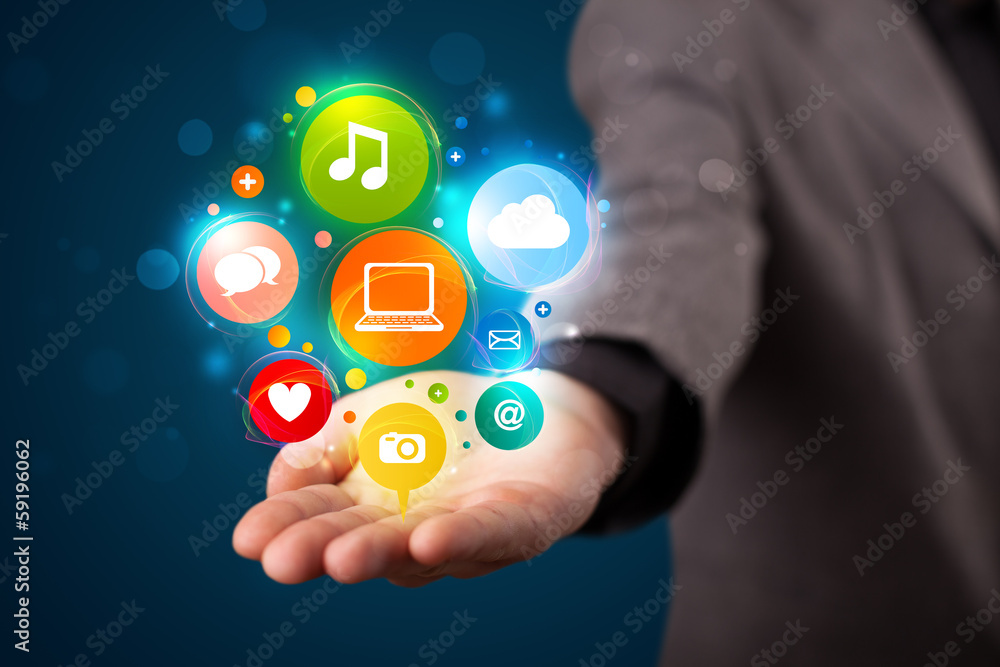 Young businessman presenting colorful technology icons and symbo Young businessman presenting colorful technology icons and symbo