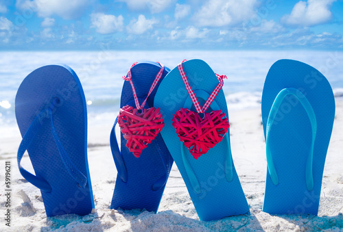 Flip flops with hearts on the beach