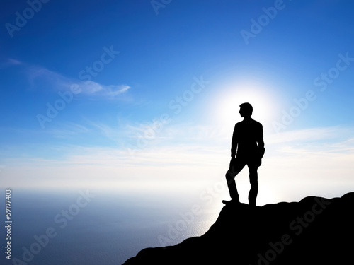 Silhouette of a winner on the mountain top. © biletskiyevgeniy.com