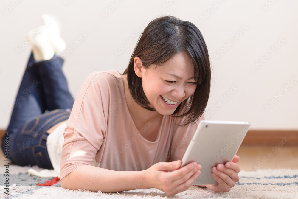 うつ伏せでタブレットpcを使う女性 Stock Photo Adobe Stock