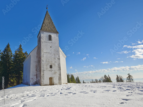 Small church on snowy hill. Slovenia, Areh, Maribor photo