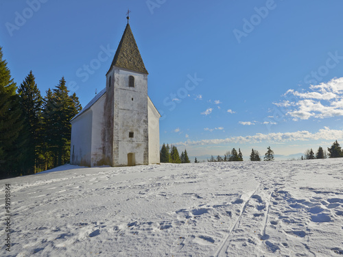 Small church on snowy hill. Slovenia, Areh, Maribor photo