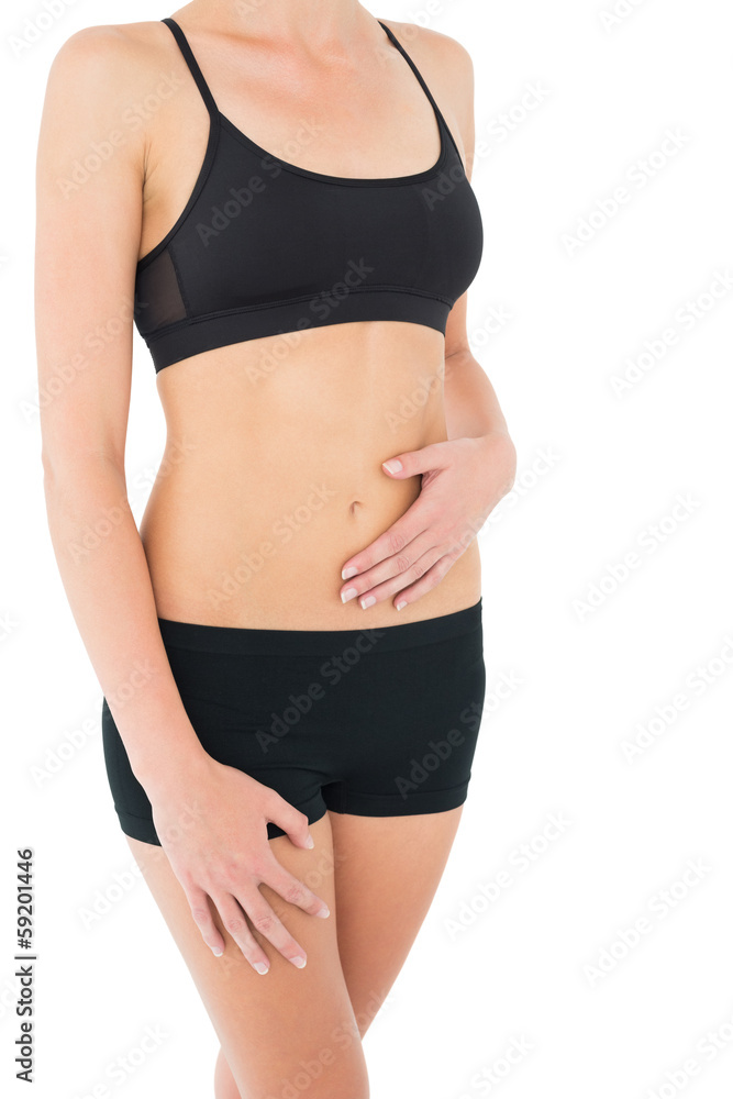 Close-up mid section of a fit woman in black sportswear Close-up mid section of a fit woman in black sportswear