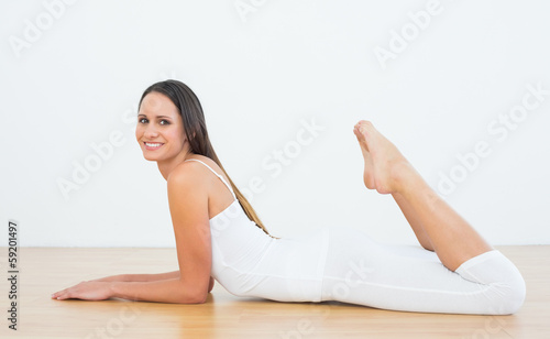 Fit woman lying on floor in fitness studio