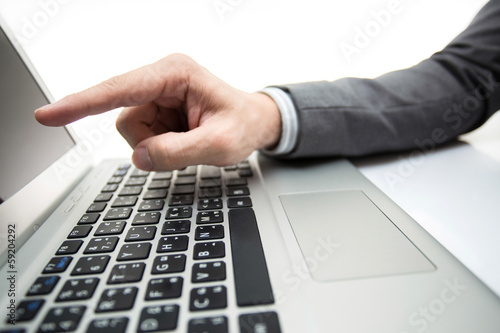 Close-up of male hands typing on laptop