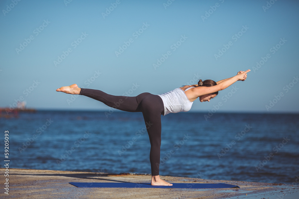 Young beautiful woman on the beach making yoga Young beautiful woman on the beach making yoga