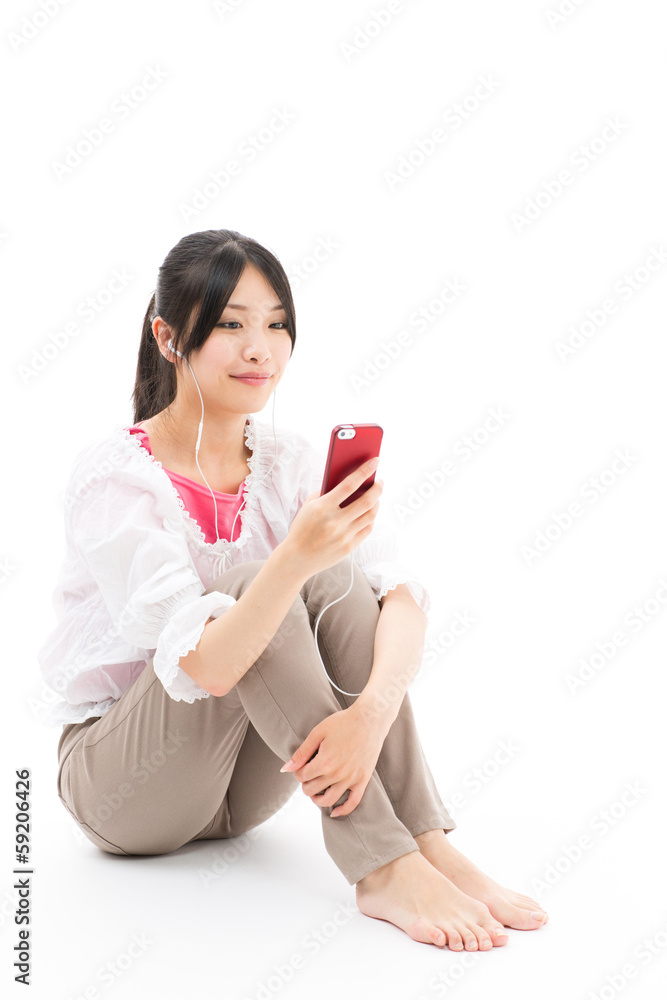 Naklejka premium young asian woman listening to music on white background