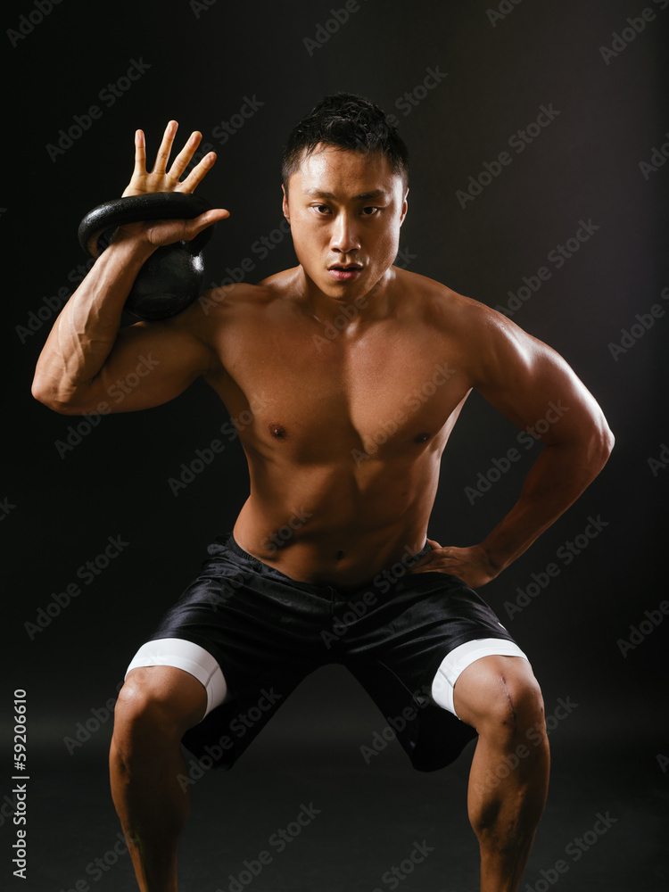 Holding a kettlebell and doing squats Holding a kettlebell and doing squats