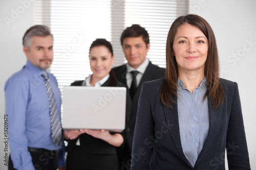 Successful smiling middle age woman looking at camera.