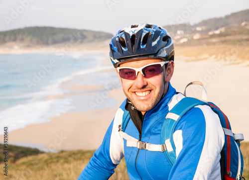 Cyclist smiling and looking at camera © ramonespelt