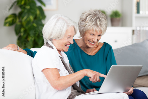 zwei ältere damen mit laptop zu hause