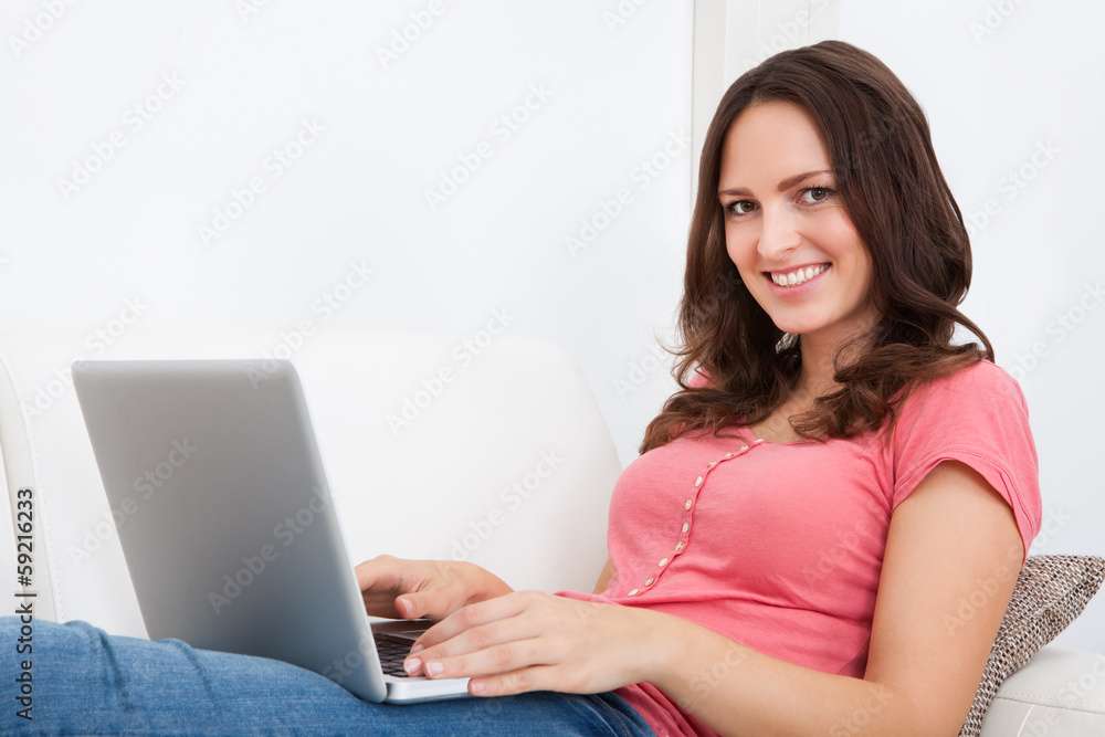 Woman Sitting On Couch Using Laptop Woman Sitting On Couch Using Laptop