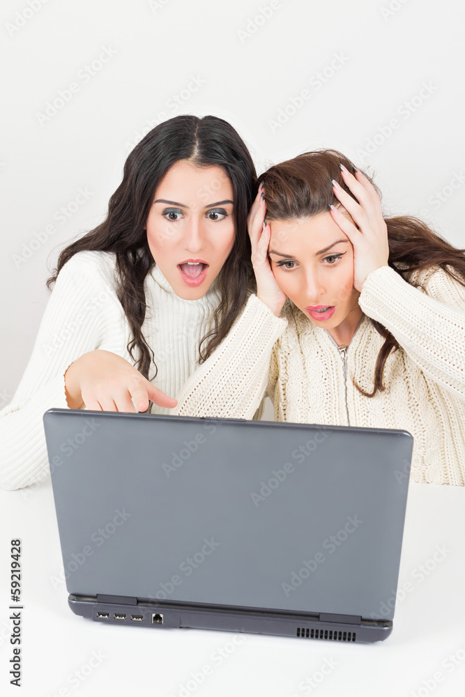 Teen friends read surprising news on the internet Teen friends read surprising news on the internet