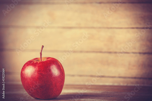 red apple on wooden table. Photo in retro color style.