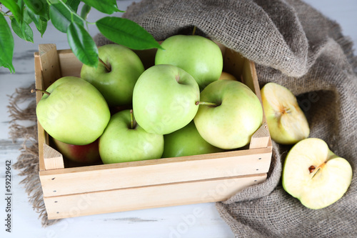Juicy apples in box on wooden table