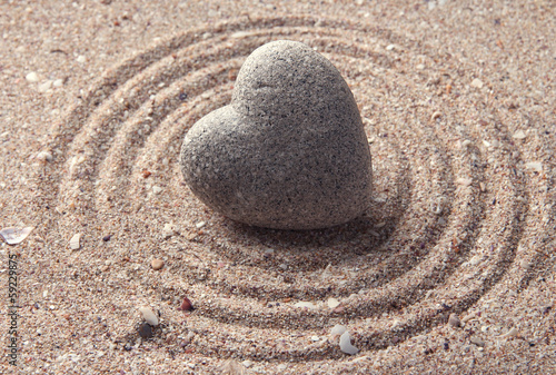 Photography Grey zen stone in shape of heart, on sand background