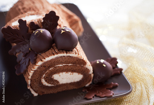 Traditional Christmas Yule Log cake with chocolate chestnuts